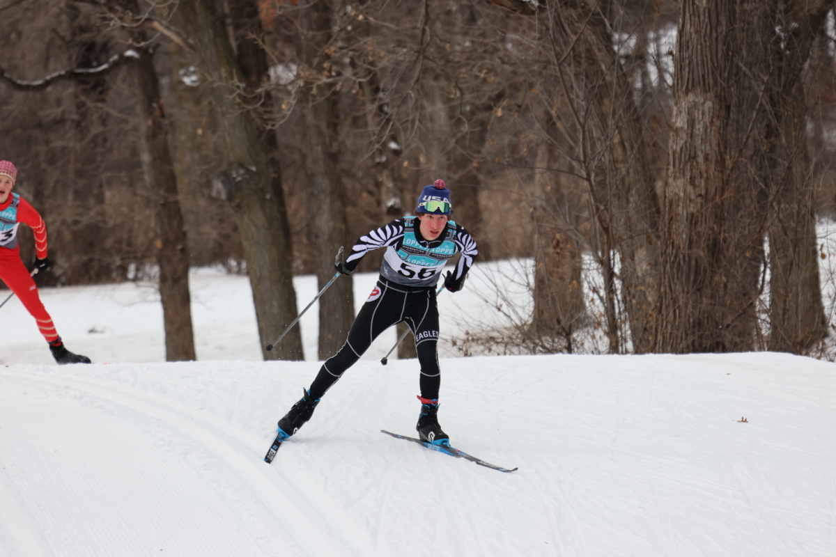 Young man cross country skier glides down a slope.