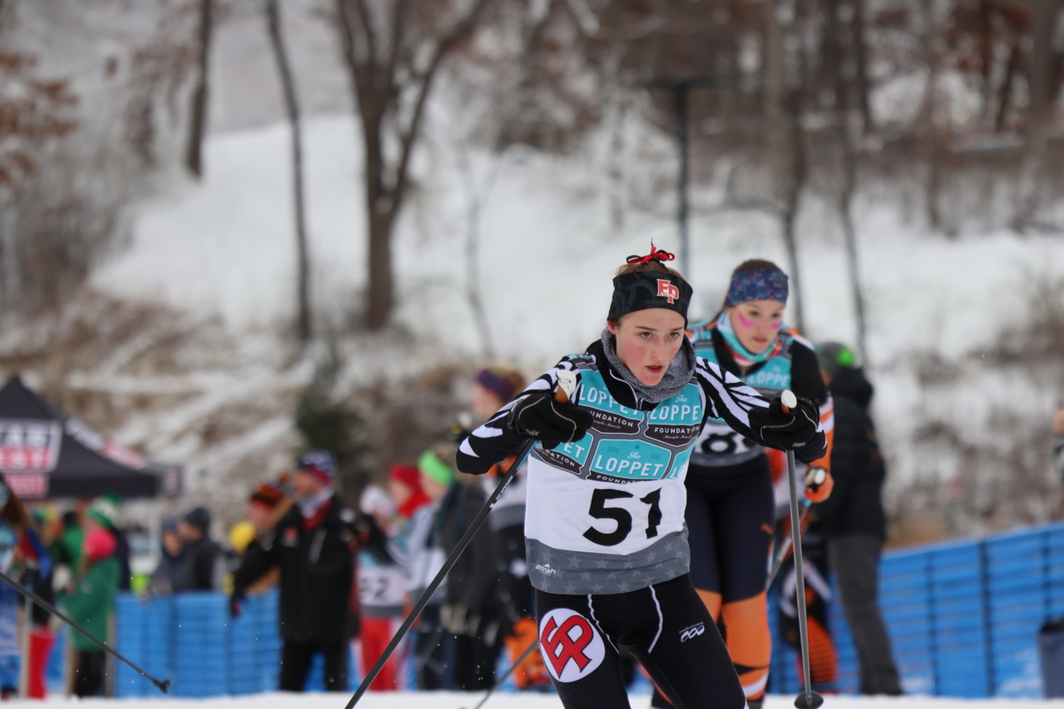 young woman cross country skier with No. 51 bib leads a race